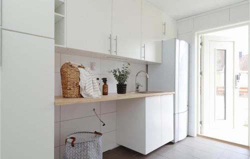a kitchen with white cabinets and a refrigerator at Gorgeous Home In Lammhult in Lammhult