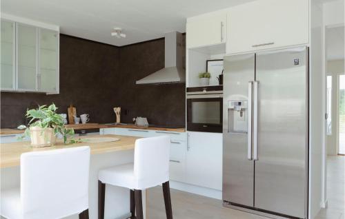 a kitchen with white cabinets and a stainless steel refrigerator at Gorgeous Home In Lammhult in Lammhult