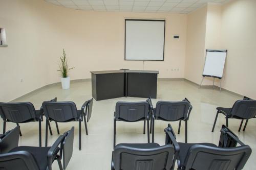 a room with chairs and a table and a screen at Sin-Kom Hotel Garni in Pirot