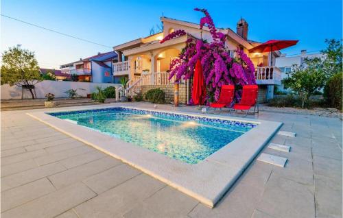 a house with a swimming pool in front of a house at 3 Bedroom Nice Home In Privlaka in Privlaka