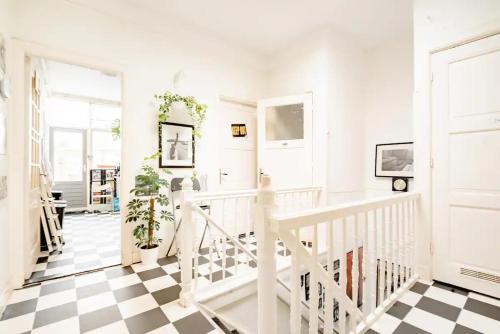 a white hallway with a black and white checkered floor at Cozy private room in shared apartment, close to beach and city center in The Hague