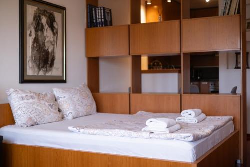 a bedroom with a bed with towels on it at Central Park Apartments in Belgrade