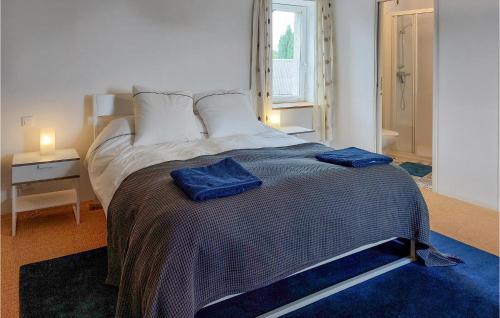 une chambre avec un lit avec deux serviettes bleues dessus dans l'établissement Gorgeous Home In Saint-Clet With Wifi, à Saint-Clet