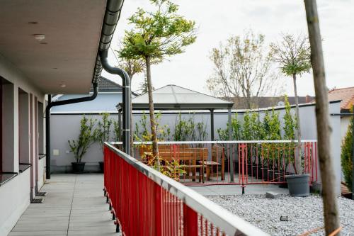 a balcony with a red fence and a table and chairs at Nava Motel SELF CHECK-IN in Wiener Neustadt