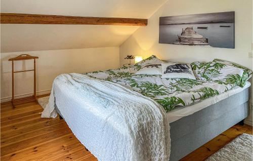 a bedroom with a bed with a blanket on it at Nice Home In Hjältevad With Sauna in Hjältevad