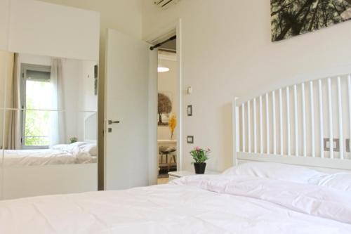 a bedroom with a white bed and a mirror at Modern 1BR Apartment in Palm Hills Near AUC New Cairo in Cairo