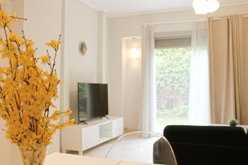 a living room with a tv and a vase at Modern 1BR Apartment in Palm Hills Near AUC New Cairo in Cairo