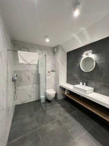 a bathroom with a sink and a toilet and a mirror at Stylchyn 90 Apartamenty nad Jeziorem Czorsztyńskim in Kluszkowce