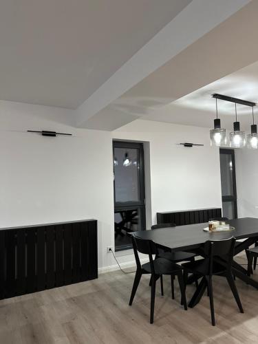 ein Esszimmer mit einem schwarzen Tisch und Stühlen in der Unterkunft Apartament Bucuresti Nord in Bukarest
