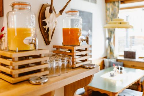 two jars of orange juice sitting on a wooden table at Seehotel Berau in St. Wolfgang