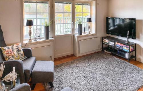 a living room with a flat screen tv and windows at Nice Home In Hjältevad With Sauna in Hjältevad