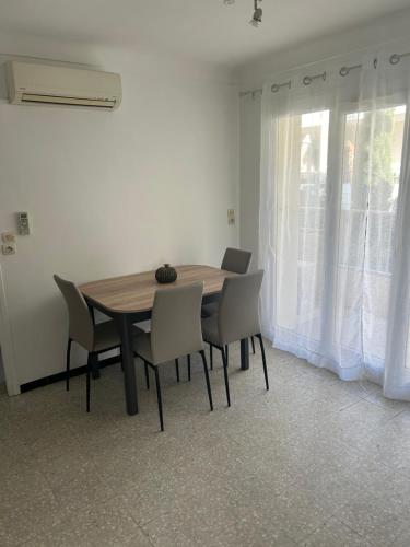 - une table à manger et des chaises dans une pièce avec fenêtre dans l'établissement Ravissant T1, à Canet