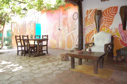 a room with chairs and a table and a wall at Posada Argimon in San Marcos Sierras