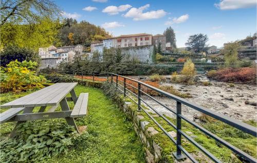 a park bench sitting next to a river at 2 Bedroom Amazing Home In Olliergues in Olliergues