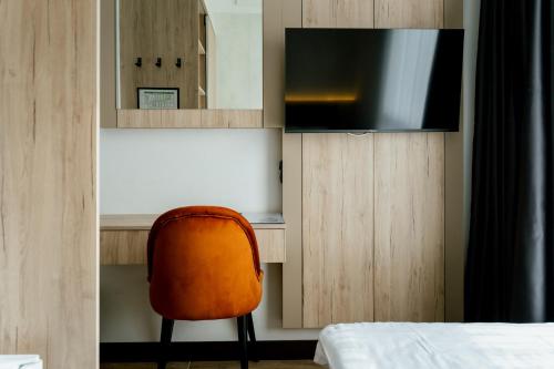 a room with a chair and a desk with a television at Lamede SELF CHECK-IN in Wiener Neustadt