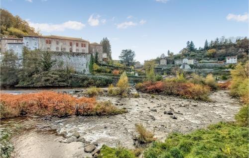 a river in a city with buildings in the background at 2 Bedroom Amazing Home In Olliergues in Olliergues