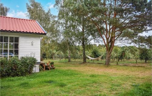 a white house with a hammock in a yard at Lovely Home In Simrishamn With Kitchen in Simrishamn