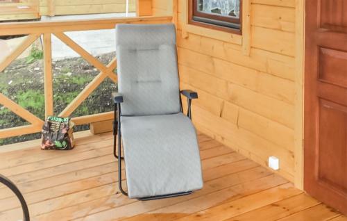 a chair sitting on the porch of a tiny house at Gorgeous Home In Rybical With Kitchen in Ryn