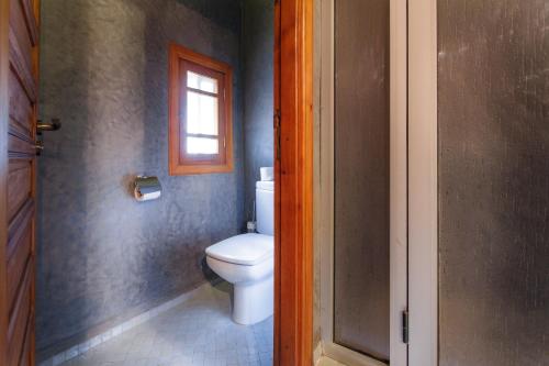 a bathroom with a toilet and a window at Riad Andalib in Fès