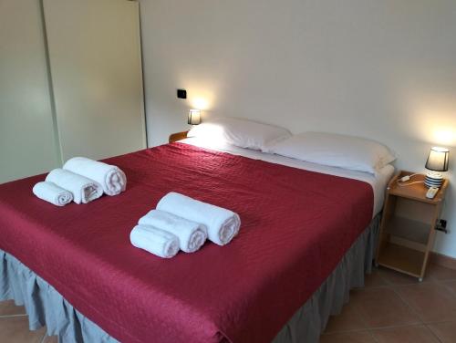 una camera da letto con un letto e tre asciugamani pieghevoli di Villa Anna near Rome a Anguillara Sabazia