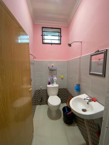 a pink bathroom with a toilet and a sink at Habib Homestay in Kuala Terengganu