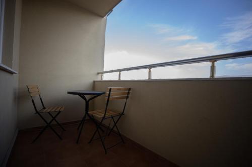 two chairs and a table sitting on a balcony at Dodona ApartHotel in Prishtina in Pristina