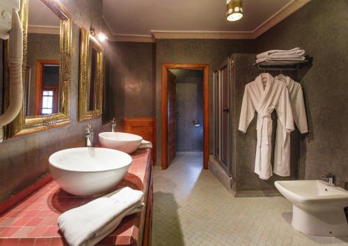 a bathroom with two sinks and a robe hanging on a wall at Riad Andalib in Fès