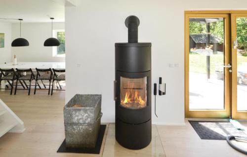 a fireplace in a living room with a table at 6 Bedroom Stunning Home In Grenaa in Grenå
