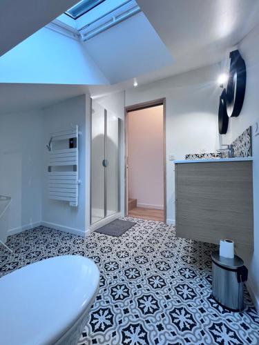 a bathroom with a white tub and a tile floor at Appartement Lancieux in Lancieux