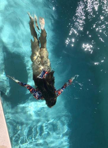 a person is swimming in the water at Anassa Villas in Vráchos