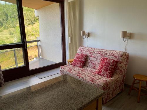 a living room with a couch and a large window at Studio aux pieds des pistes in Villard-de-Lans