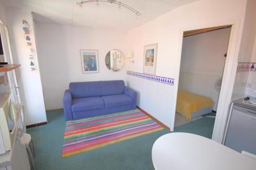 Cette petite chambre comprend une chaise bleue et un tapis. dans l'établissement Treille 3 3ème étage, à Collioure