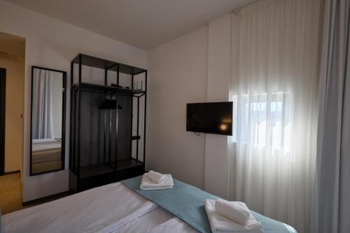 a bedroom with a bed with a mirror and a tv at Bizarre Boutique Hotel in Varna City