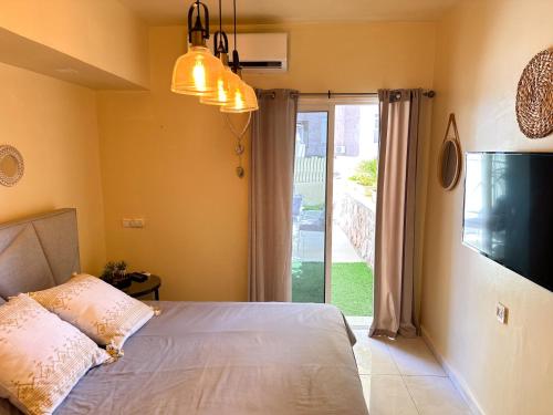 ein Schlafzimmer mit einem Bett und einer Glasschiebetür in der Unterkunft דירת נופש אילת -אלמוג Almog Suite in Eilat close to Red Sea - דירת נופש אלמוג מרחק נגיעה מהים in Eilat