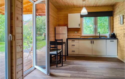 una cucina in una cabina di legno con tavolo e sedie di Nice Home In Karszewo With Wi-Fi a Karszewo