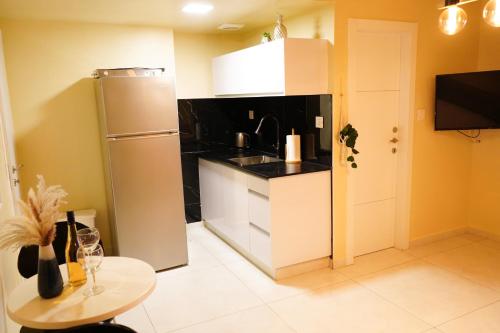eine kleine Küche mit Kühlschrank und Tisch in der Unterkunft דירת נופש אילת -אלמוג Almog Suite in Eilat close to Red Sea - דירת נופש אלמוג מרחק נגיעה מהים in Eilat