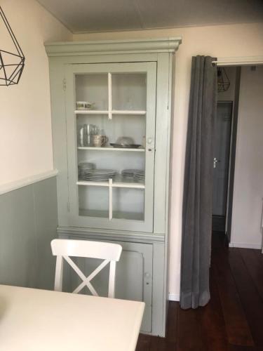 a kitchen with a cabinet with dishes in it at Appartement in schuur in Twisk