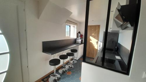 a kitchen with a mirror and stools in a room at L'Olivaie - Calme, confort et vue imprenable in Seillans