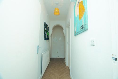 a hallway with a white hallway with a door and a light at Spacious 2 bed house, FREE parking, Gateshead in Gateshead