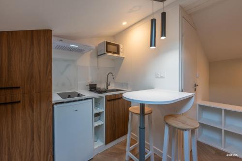 une petite cuisine avec un comptoir blanc et un évier dans l'établissement Montsejour - Magnifique studio neuf, à Toulouse