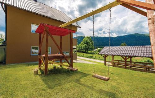 a swing set in a yard next to a house at One-Bedroom Apartment In Ogulin in Jasenak