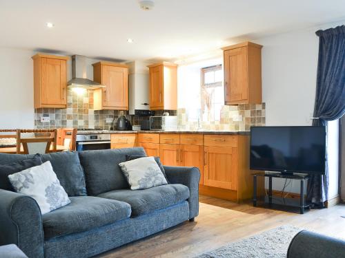 a living room with a couch and a kitchen at Meadow Lodge-E4105 in Aspatria