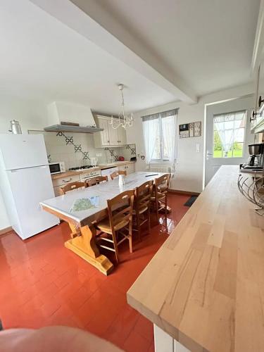 une cuisine avec une table et des chaises dans une pièce dans l'établissement Maison accueillante à Petit-Caux avec jardin, à Tocqueville-sur-Eu