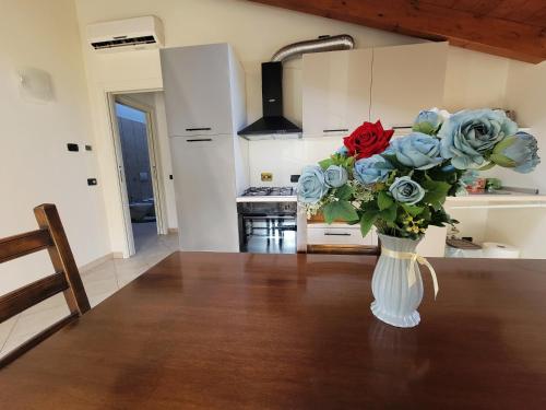 a vase of roses on a table in a kitchen at Podere Elisa in Vezzano sul Crostolo