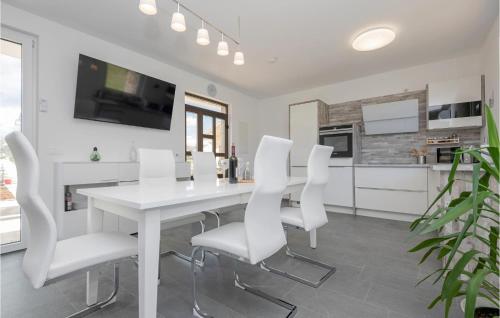 a white dining room with a white table and white chairs at Lovely Home In Donji Prolozac With Wifi in Donji Proložac