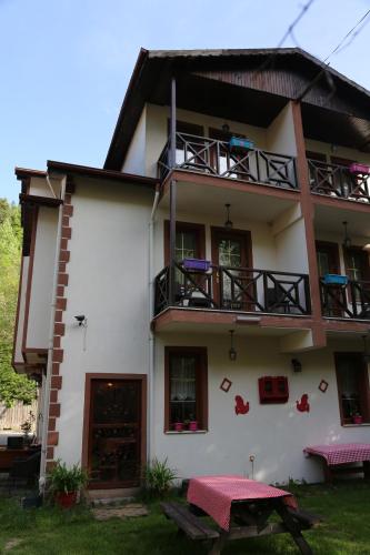 a white building with a table in front of it at ABANT DORT MEVSİM KONAĞI HOSTEL in Dereceören