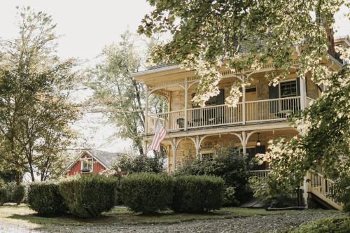 a house with an american flag in front of it at Fallen Tree Farm Bed and Breakfast in Carlisle