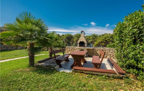 a picnic table and benches in front of a building at 3 Bedroom Beautiful Apartment In Krk in Krk