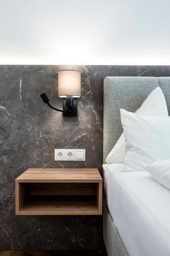 a bed with a lamp on a night stand next to a bed at Hotel Gasthof Brüggler in Radstadt
