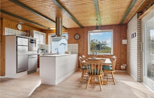 a kitchen with a wooden ceiling and a table with chairs at 3 Bedroom Beautiful Home In Spøttrup in Spottrup